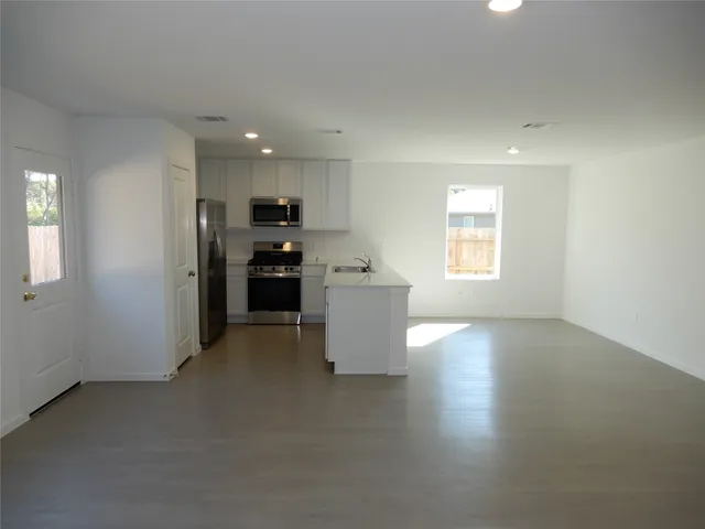 a view of a kitchen with a sink a refrigerator and window