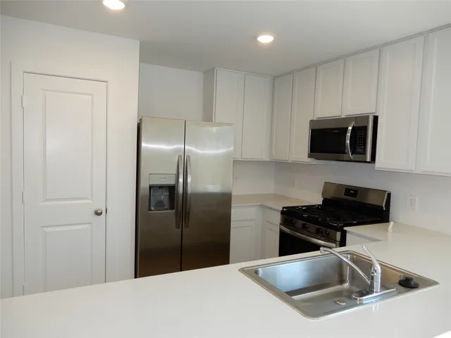 a kitchen with a refrigerator and a sink