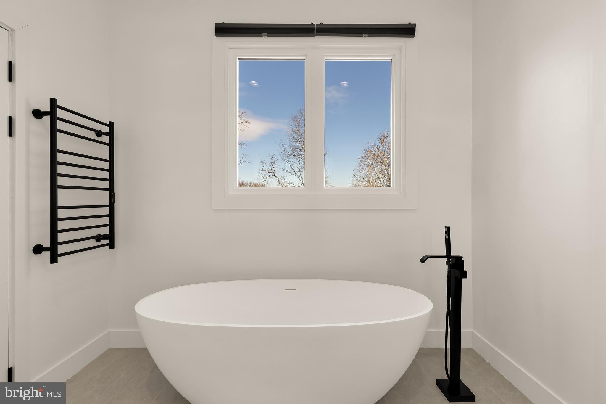 14051 Esworthy Road Darnestown, MD 20874 - Photo 22 of 50 a white bath tub sitting in a bathroom