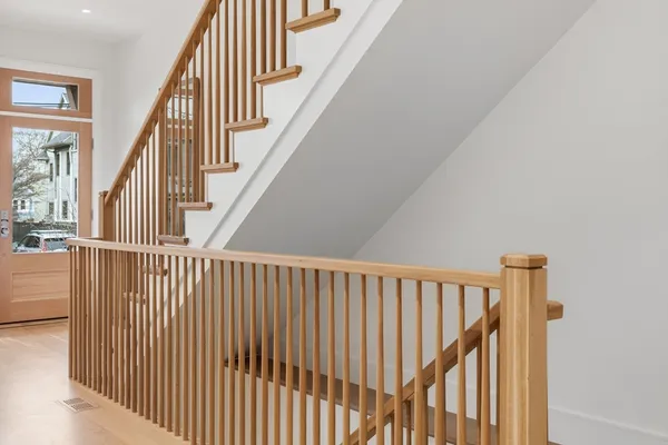 a view of staircase with railing and white walls