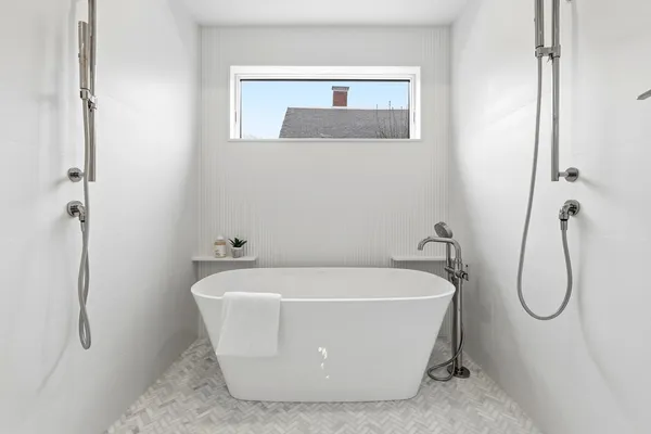 a white bath tub sitting next to a shower