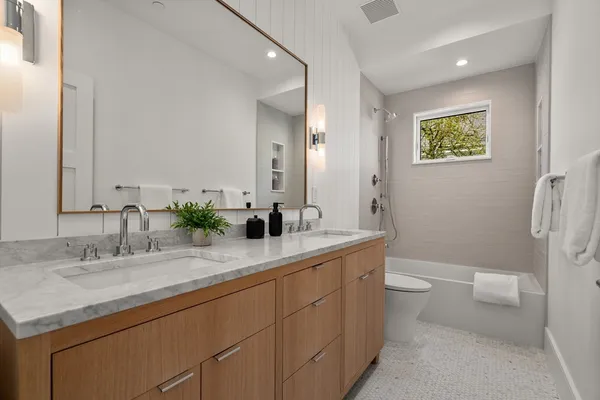 a bathroom with a granite countertop sink mirror vanity and toilet