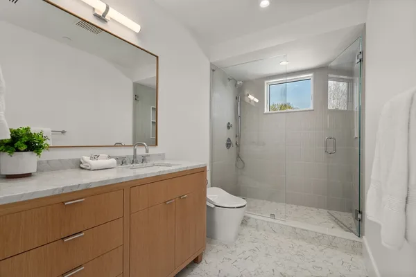 a bathroom with a granite countertop sink a toilet and shower