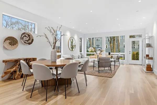 a view of a dining room and livingroom with furniture wooden floor and a clock