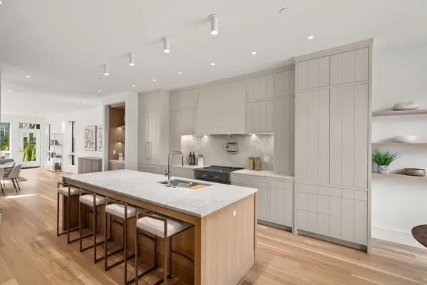 a large kitchen with kitchen island a stove a table and chairs