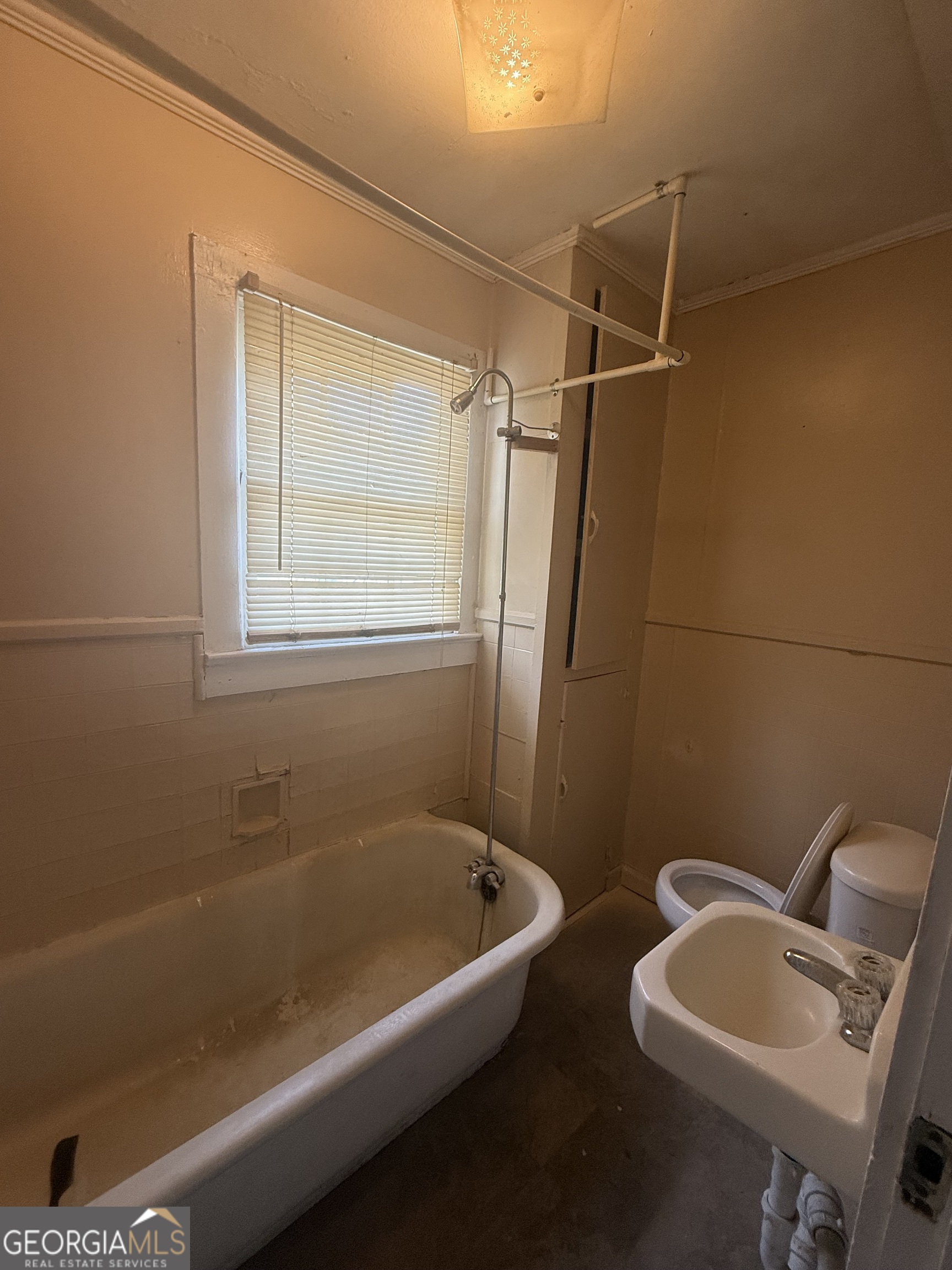 902 1st Street Lanett, AL 36863 - Photo 4 of 6 a bathroom with a tub a sink and a window