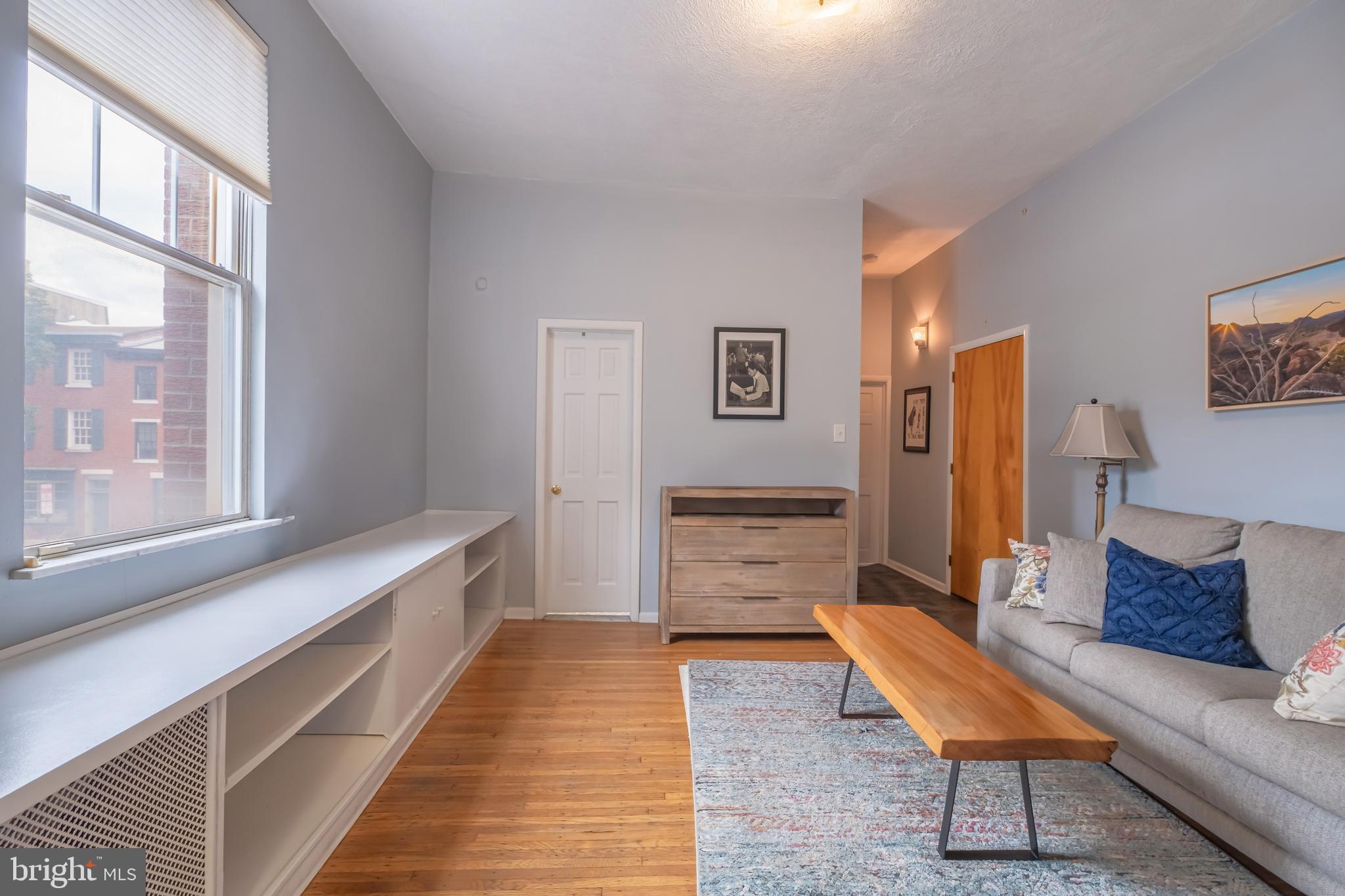 1701 Pine Street Philadelphia, PA 19103 - Photo 5 of 16 a hallway with a couch and dresser with wooden floor