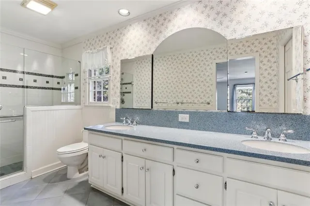 a bathroom with a granite countertop toilet sink and mirror