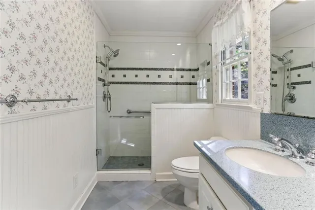 a bathroom with a granite countertop toilet sink and mirror