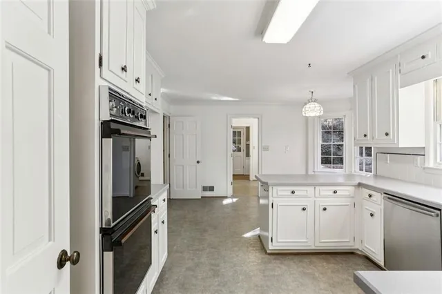 a kitchen with white cabinets and refrigerator