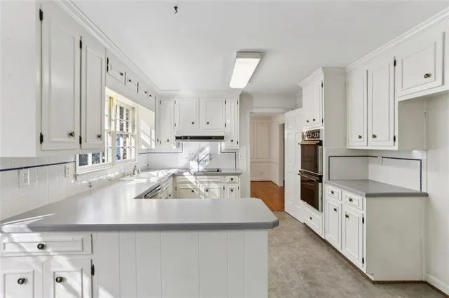 a kitchen with granite countertop a sink a stove and refrigerator