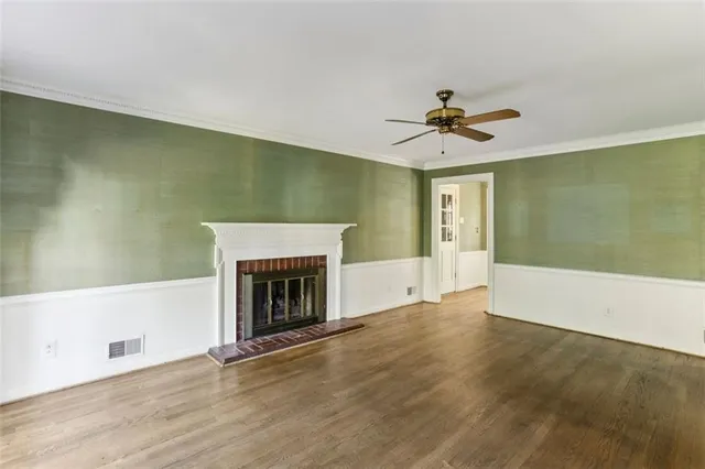 an empty room with a fireplace and fan