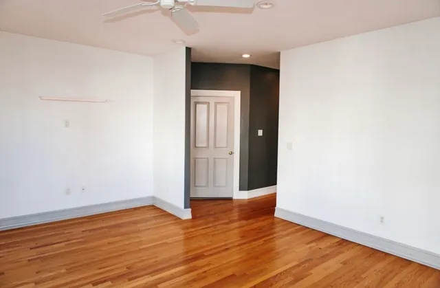 an empty room with wooden floor and entrance