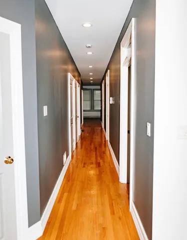 a view of a hallway with wooden floor and staircase