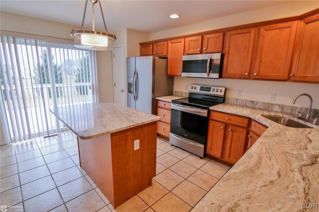 4167 Ross Road Bethlehem, PA 18020 - Photo 11 of 27 a kitchen with stainless steel appliances wooden cabinets a stove top oven a sink and dishwasher