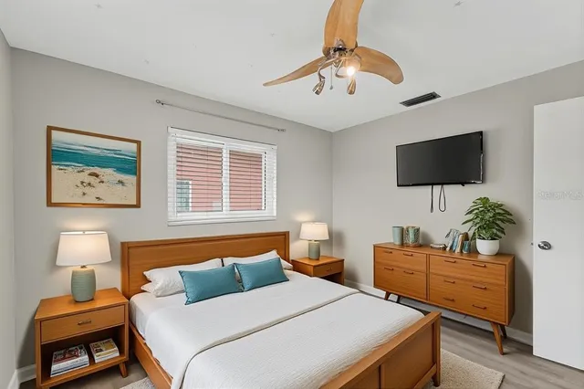 a bedroom with a bed and a potted plant