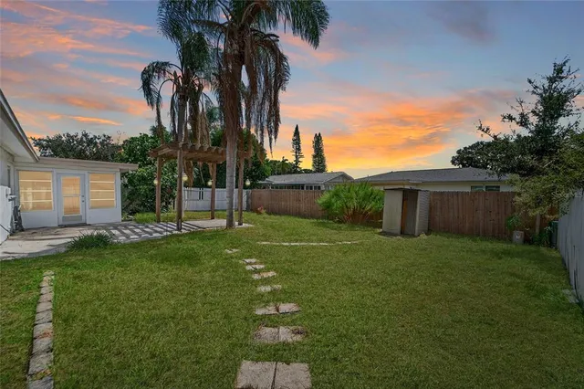 a view of three trees and front of house