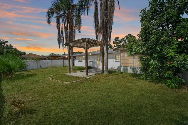 a front view of a house with a yard and potted plants