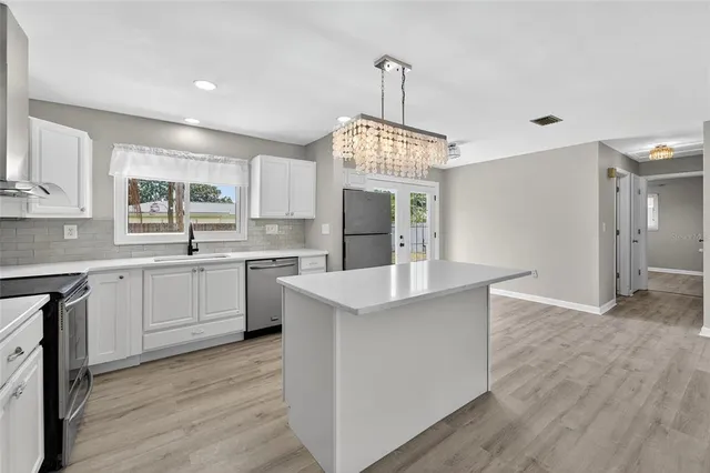 a kitchen with refrigerator cabinets and wooden floor