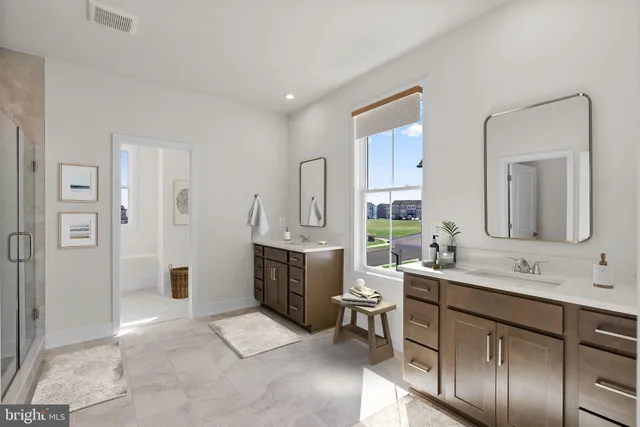 a spacious bathroom with a double vanity sink a mirror and a shower