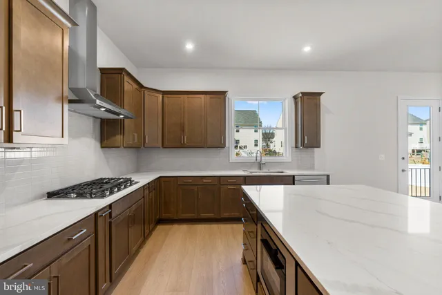 a kitchen with stainless steel appliances a sink stove and cabinets