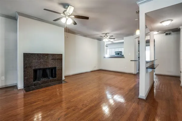 a view of empty room with wooden floor and a fireplace