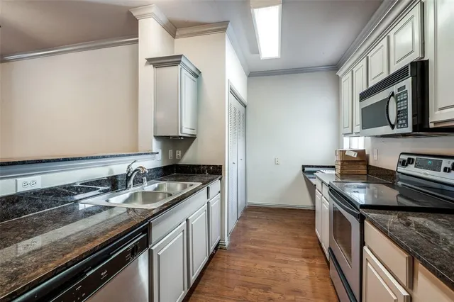 a kitchen with stainless steel appliances granite countertop a sink stove and cabinets