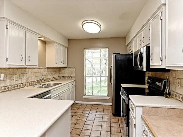 a kitchen with a sink stove top oven and cabinets