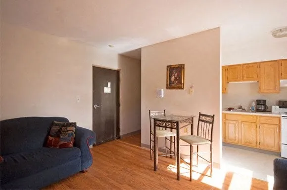 a living room with furniture and a kitchen area