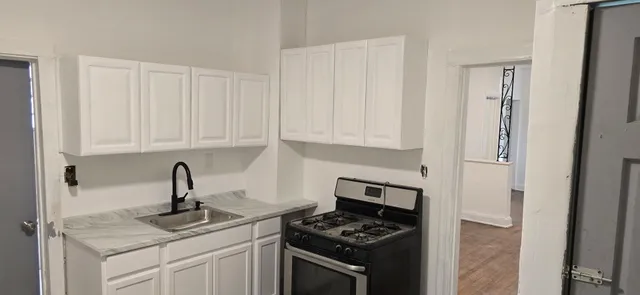 a kitchen with stainless steel appliances granite countertop white cabinets and a stove