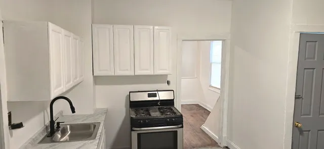 a kitchen with a refrigerator and a stove top oven