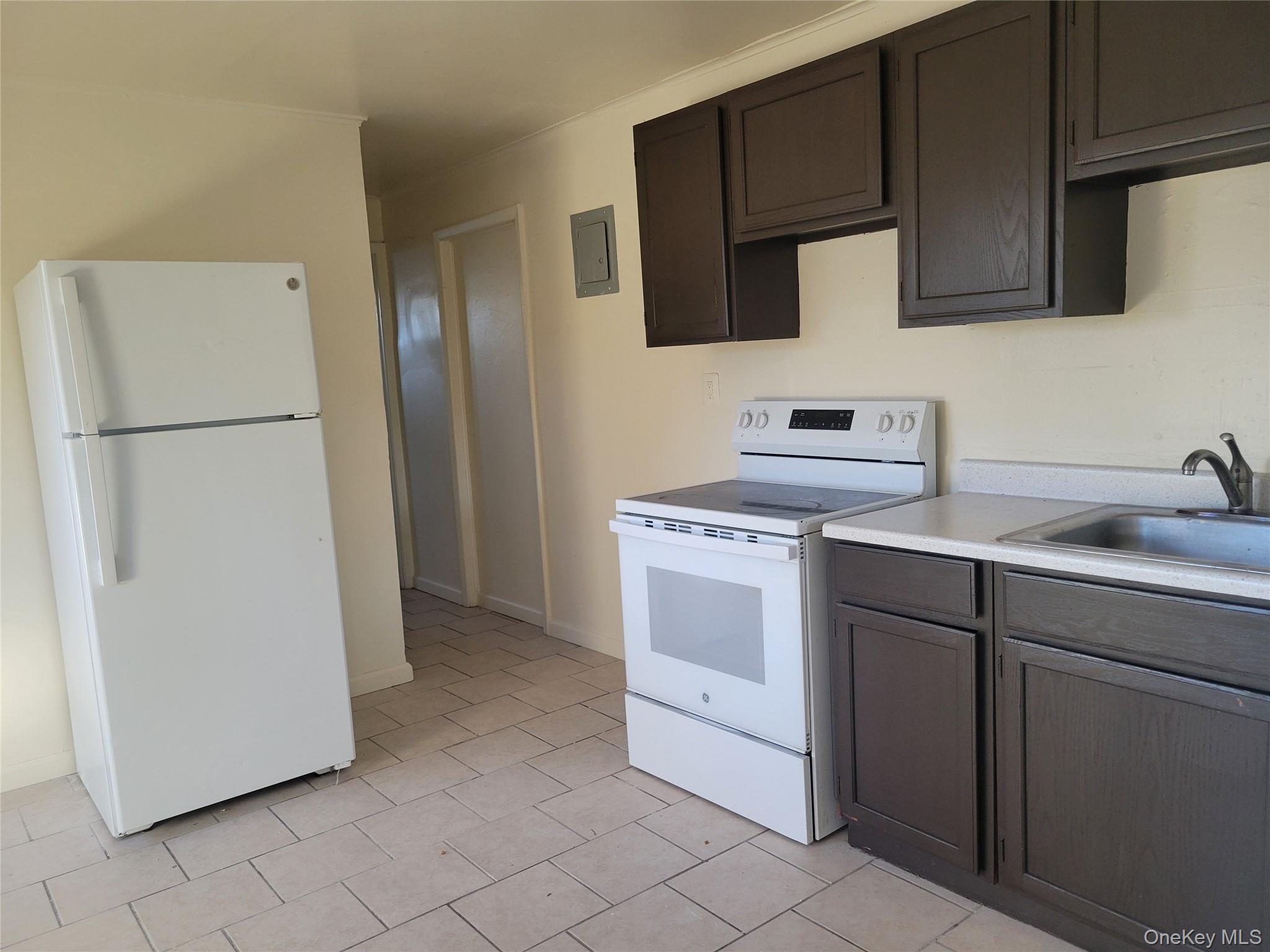 3479 Lexington Avenue, Unit L8 Mohegan Lake, NY 10547 - Photo 2 of 6 a kitchen with a sink a refrigerator and cabinets