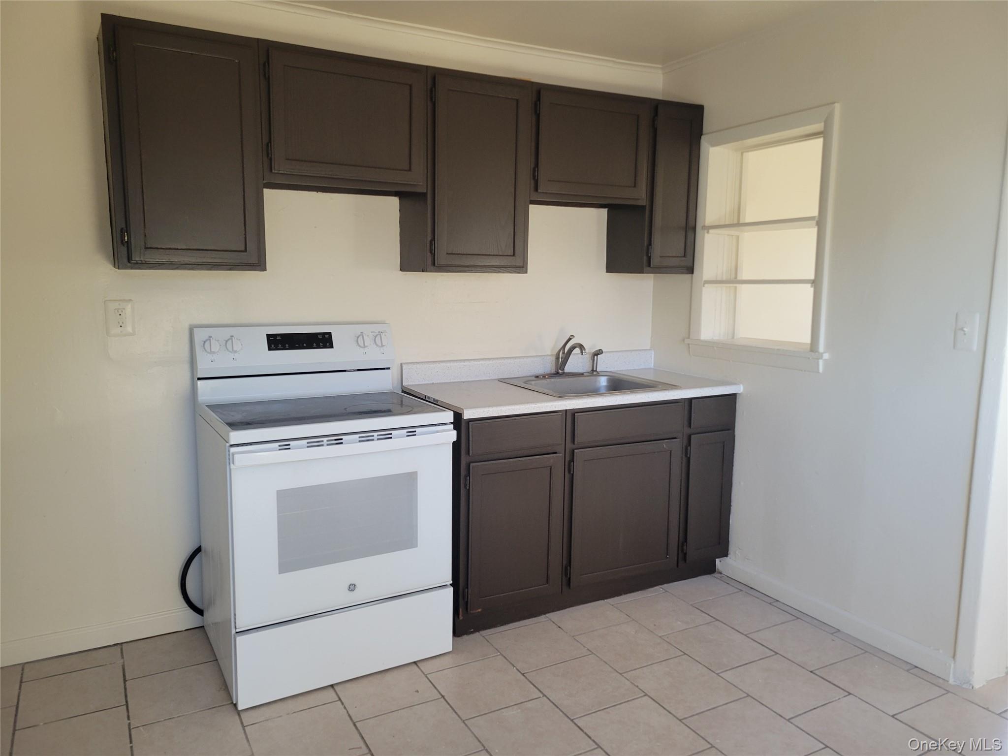 3479 Lexington Avenue, Unit L8 Mohegan Lake, NY 10547 - Photo 3 of 6 a kitchen with a stove sink and cabinets