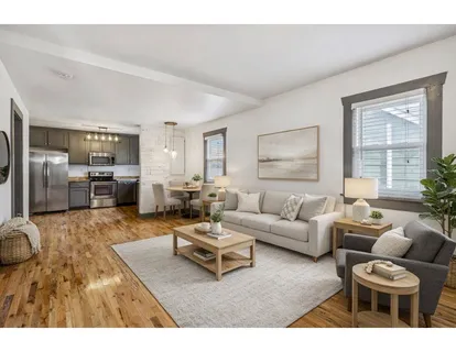 a living room with furniture and a kitchen