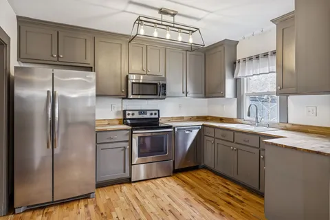 a view of kitchen with granite countertop cabinets and wooden floor