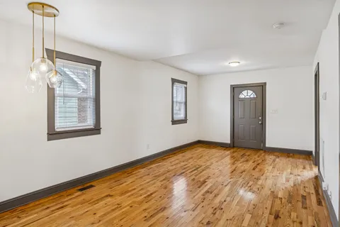 a view of a kitchen with wooden floor refrigerator and window