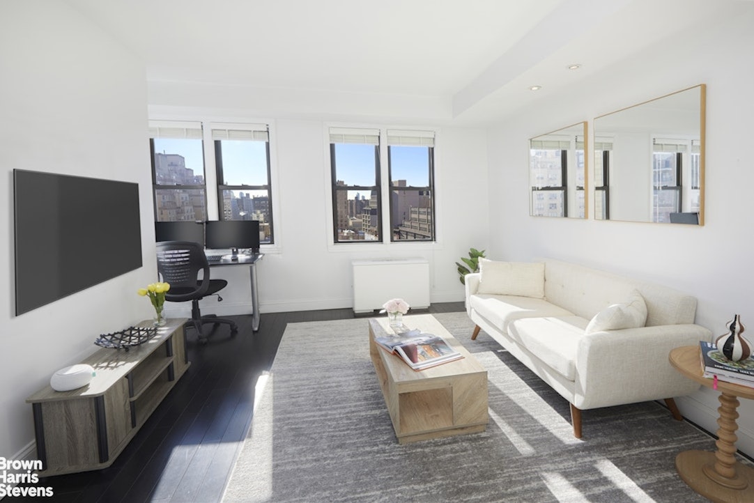 201 East 21st Street, Unit 15G Manhattan, NY 10010 - Photo 2 of 8 a living room with furniture wooden floor and a table