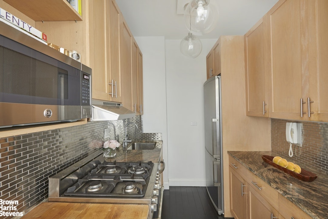 201 East 21st Street, Unit 15G Manhattan, NY 10010 - Photo 4 of 8 a kitchen with a stove and a microwave