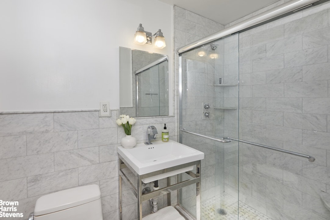 201 East 21st Street, Unit 15G Manhattan, NY 10010 - Photo 5 of 8 a bathroom with a sink a toilet and shower
