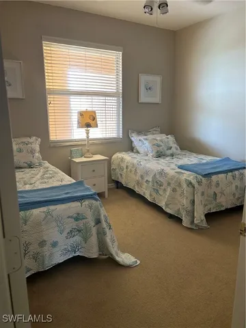 a bedroom with two beds and a window