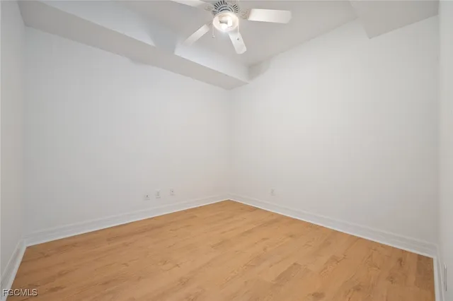 an empty room with a ceiling fan and carpet