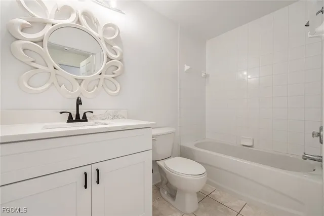 a bathroom with a toilet a sink a mirror and vanity