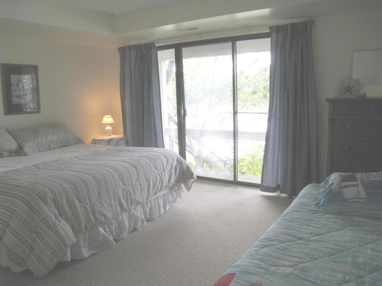 72 Clam Shell Point Lane Cotuit, MA 02635 - Photo 20 of 35 a spacious bedroom with a bed and a large window