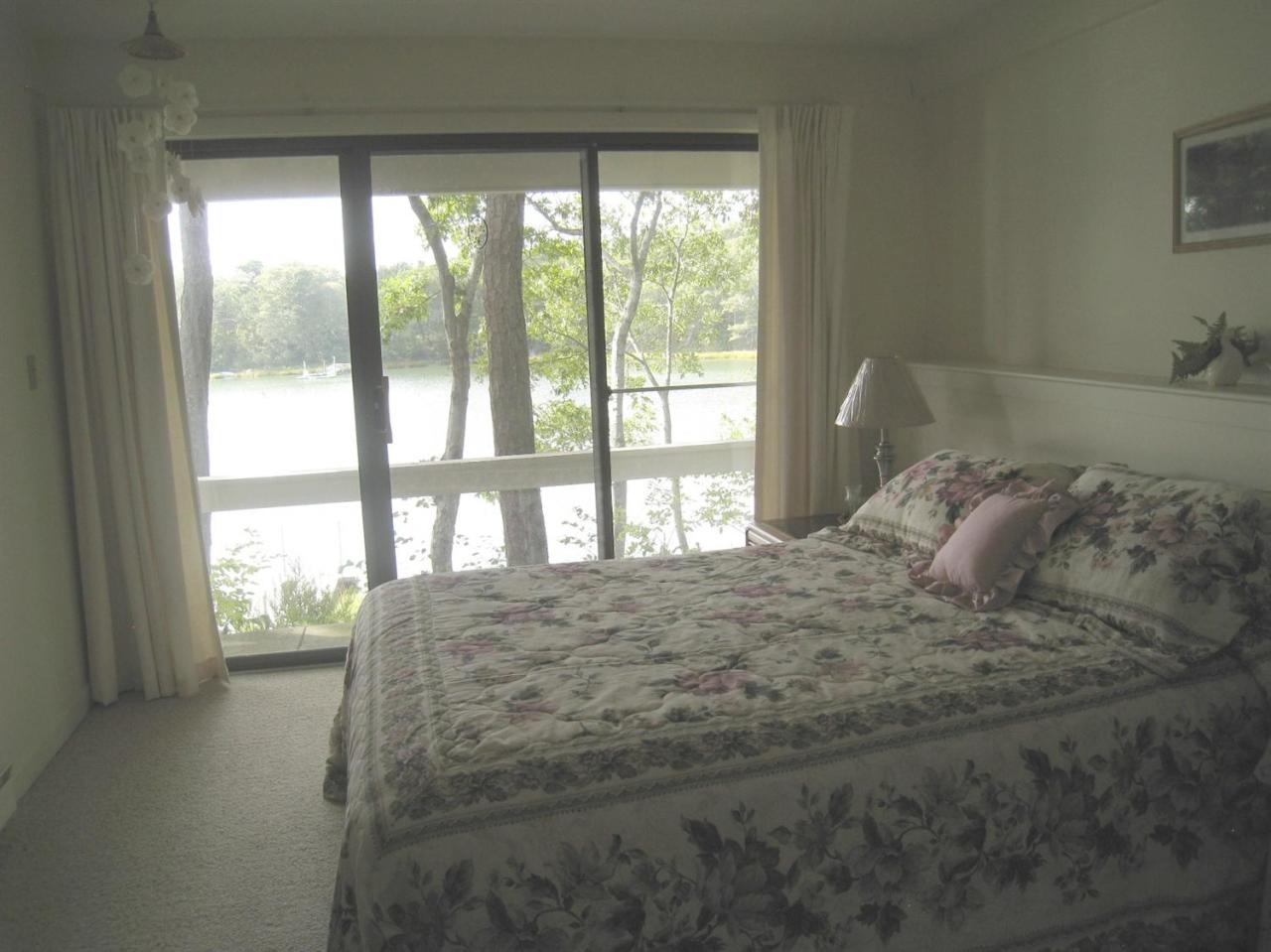 72 Clam Shell Point Lane Cotuit, MA 02635 - Photo 24 of 35 a large bed sitting in a bedroom next to a window