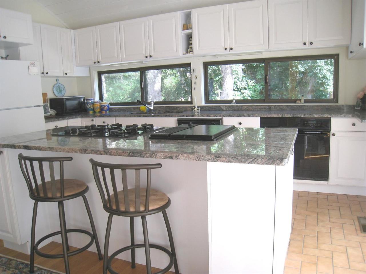 72 Clam Shell Point Lane Cotuit, MA 02635 - Photo 6 of 35 a kitchen with stainless steel appliances granite countertop a stove a sink a microwave and white cabinets