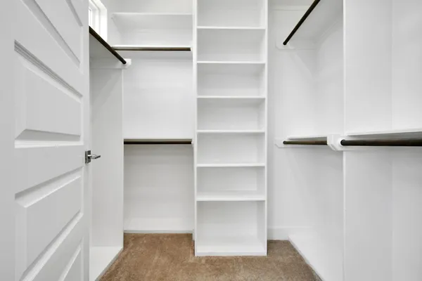 a view of walk in closet with empty racks