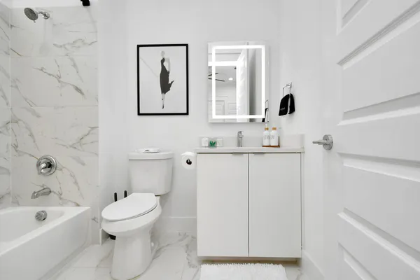 a bathroom with a toilet sink and mirror