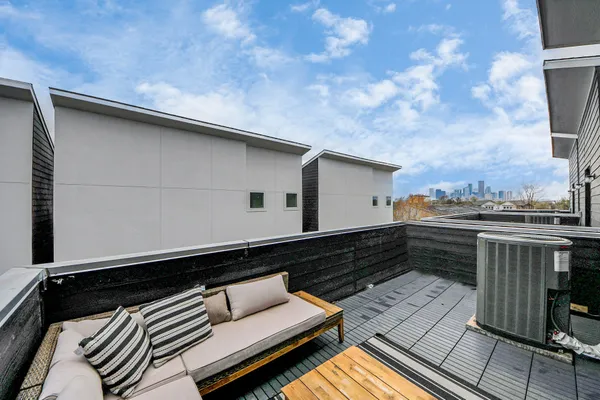 a roof deck with wooden floor and barbeque oven