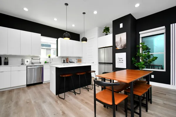 a kitchen with a table chairs sink and cabinets