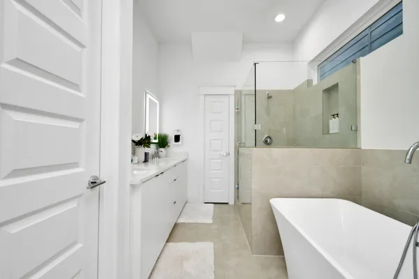 a bathroom with a tub sink and mirror